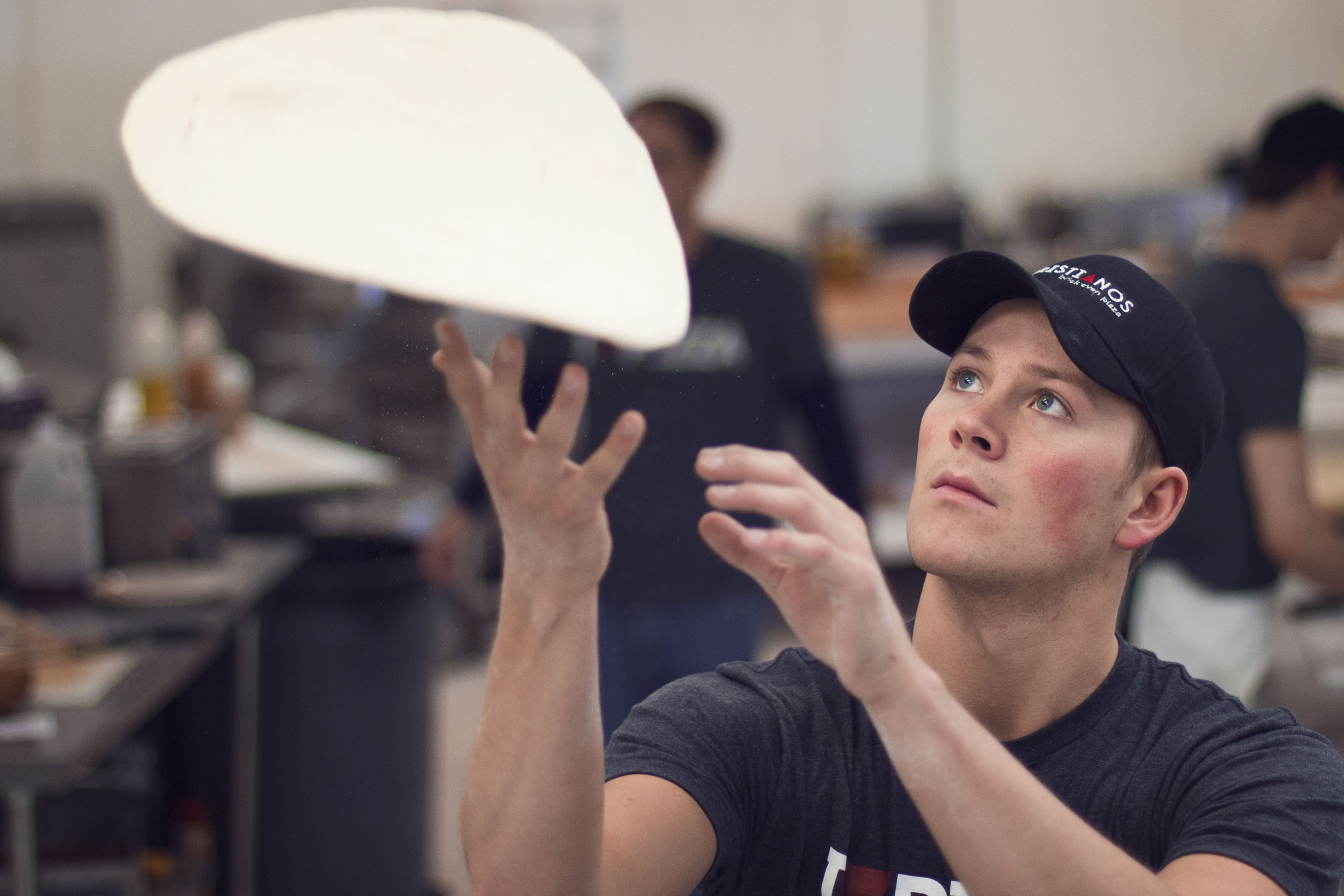 Sean Wise, son of owner Larry Wise, tosses pizza dough in Christianos kitchen
